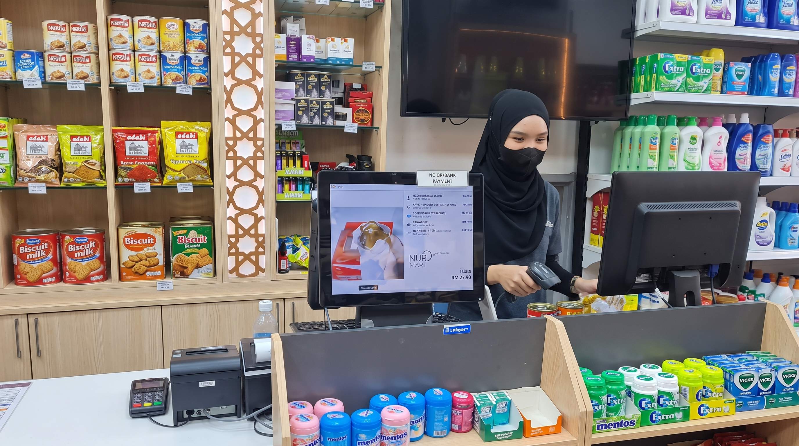 Kasir menggunakan sistem POS Odoo dengan scanner barcode dan layar pelanggan di toko retail