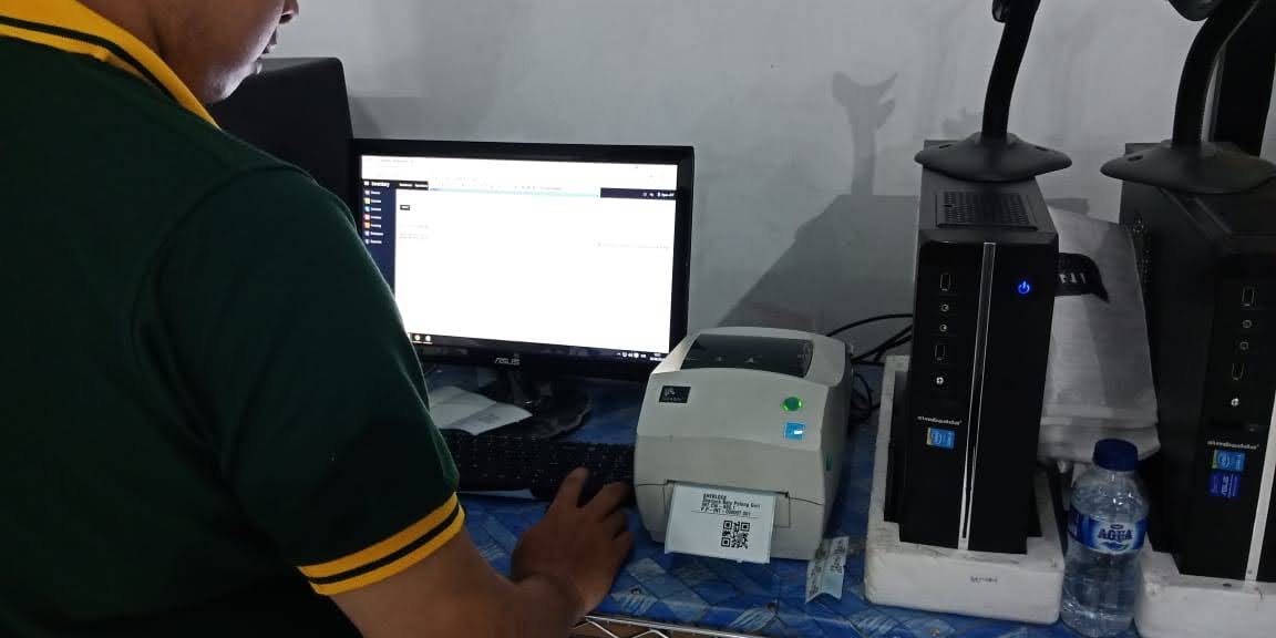 Printer label mencetak barcode produk SherlockTools di samping komputer gudang